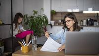 Busy bisness mother woking at home while little daughter being occupied by digital tablet