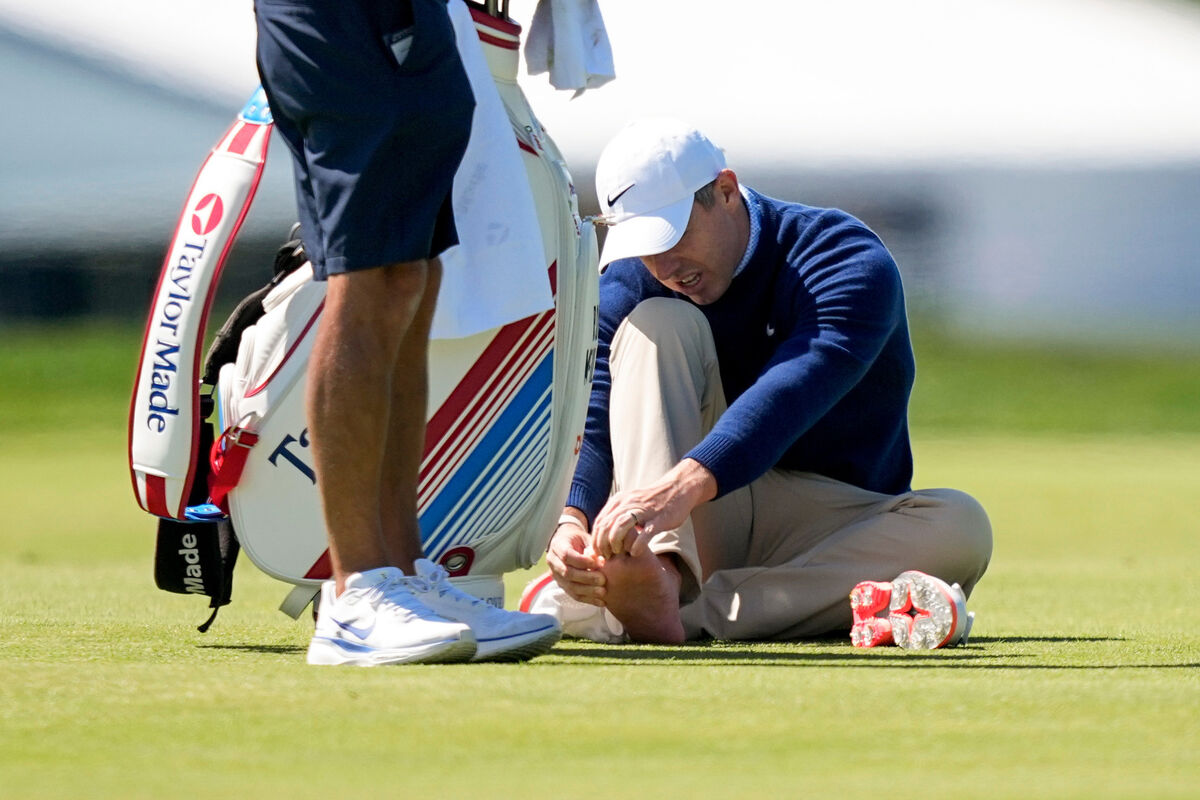 Rory McIlroy attends to his foot on the third fairway during a PGA Championship golf tournament practice round at Aronimink Golf Club. Pic: AP Photo/Matt Slocum.