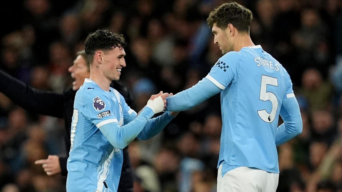 Manchester City's Phil Foden (left) passes the captain's armband to team-mate John Stones as he is substituted during the Premier League match at the Etihad Stadium. Pic: Martin Rickett/PA Wire.