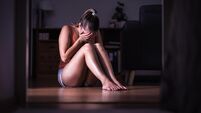 Victim of sexual harassment, domestic violence or abuse. Young sad woman crying and sitting on the floor at home. Ashamed, scare
