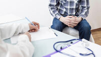 A male patient consults with a doctor about prostate cancer or some other disease.