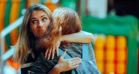Woman Hugs Fake Friend Making Faces Behind her Back