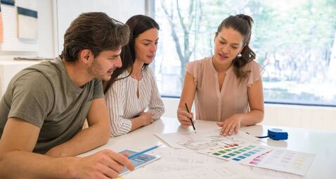 Architect sketching a remodeling plan with her clients