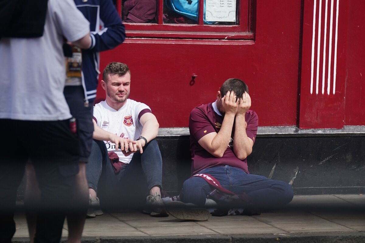 HEARTBREAK: Heart of Midlothian fans sit dejected outside a bar in Edinburgh showing the Scottish Premier League championship decider against Celtic. Pic: Jane Barlow/PA Wire. HEARTBREAK: Heart of Midlothian fans sit dejected outside a bar in Edinburgh showing the Scottish Premier League championship decider against Celtic. Pic: Jane Barlow/PA Wire.