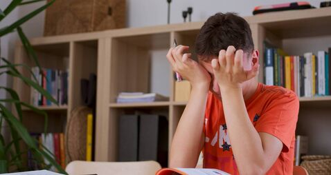 Teenager boy tired stressed of reading, doing homework