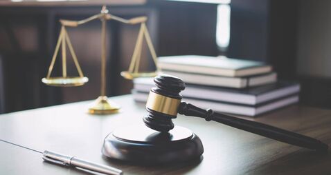 iStock-939262058.jpg Scales of justice and Gavel on wooden table and Lawyer or Judge working with agreement in Courtroom, Justice and Law concept