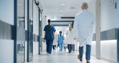 Hospital Hallway with Doctors, Nurses and Specialists in Hospital. Female and Male Physicians, Surgeons, Healthcare Officials Wa