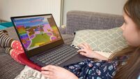 Young girl playing Roblox on laptop computer