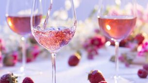<p>Glass of rosÃ© wine being poured at a picnic setting on a summer's day.</p>