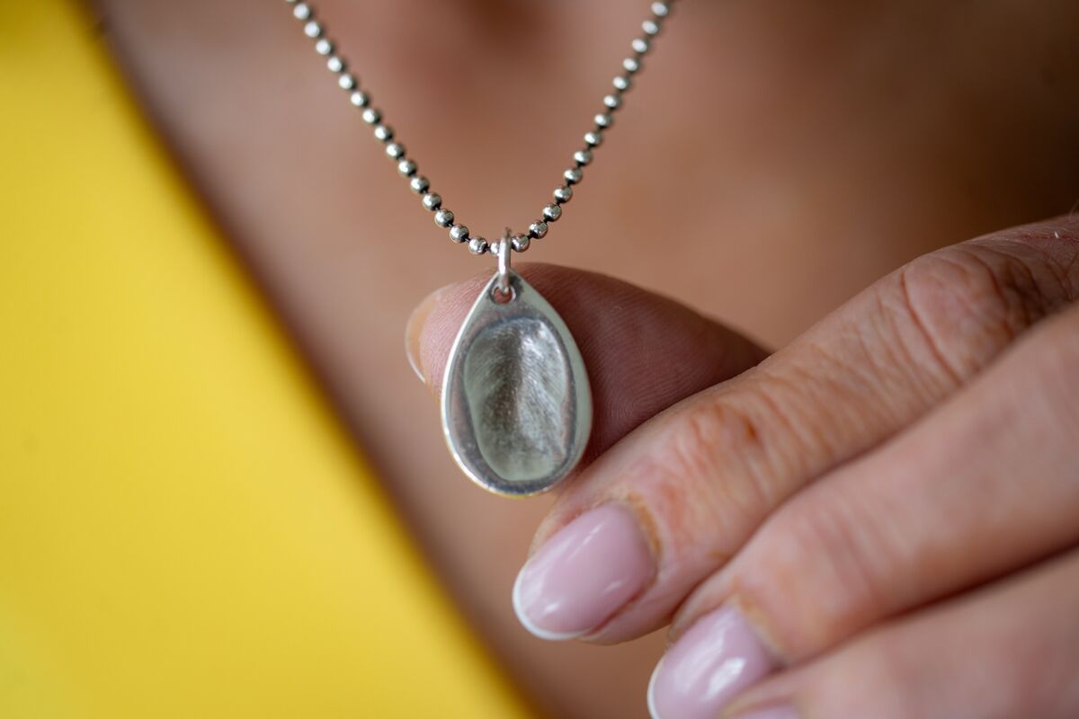 Ellen's mother Violet wearing an embossed silver pendant of her daughter's fingerprint Ellen's mother Violet wearing an embossed silver pendant of her daughter's fingerprint
