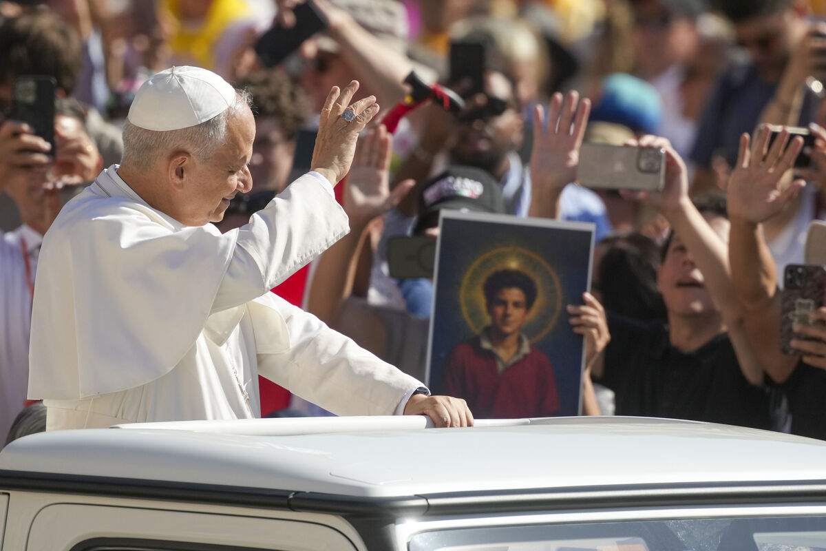 Pope Leo XIV waves to faithful holding a picture of Carlo Acutis in 2025. Picture: Andrew Medichini/AP
