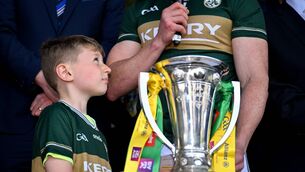 <p>SOME DAY: Páidí Geaney, looks up at his dad Paul Geaney making the victory speech with Corn Pháidí Uí Shé after Kerry's Munster SFC final win over Cork at Fitzgerald Stadium. Pic: Brendan Moran/Sportsfile</p> <p>SOME DAY: Páidí Geaney, looks up at his dad Paul Geaney making the victory speech with Corn Pháidí Uí Shé after Kerry's Munster SFC final win over Cork at Fitzgerald Stadium. Pic: Brendan Moran/Sportsfile</p>