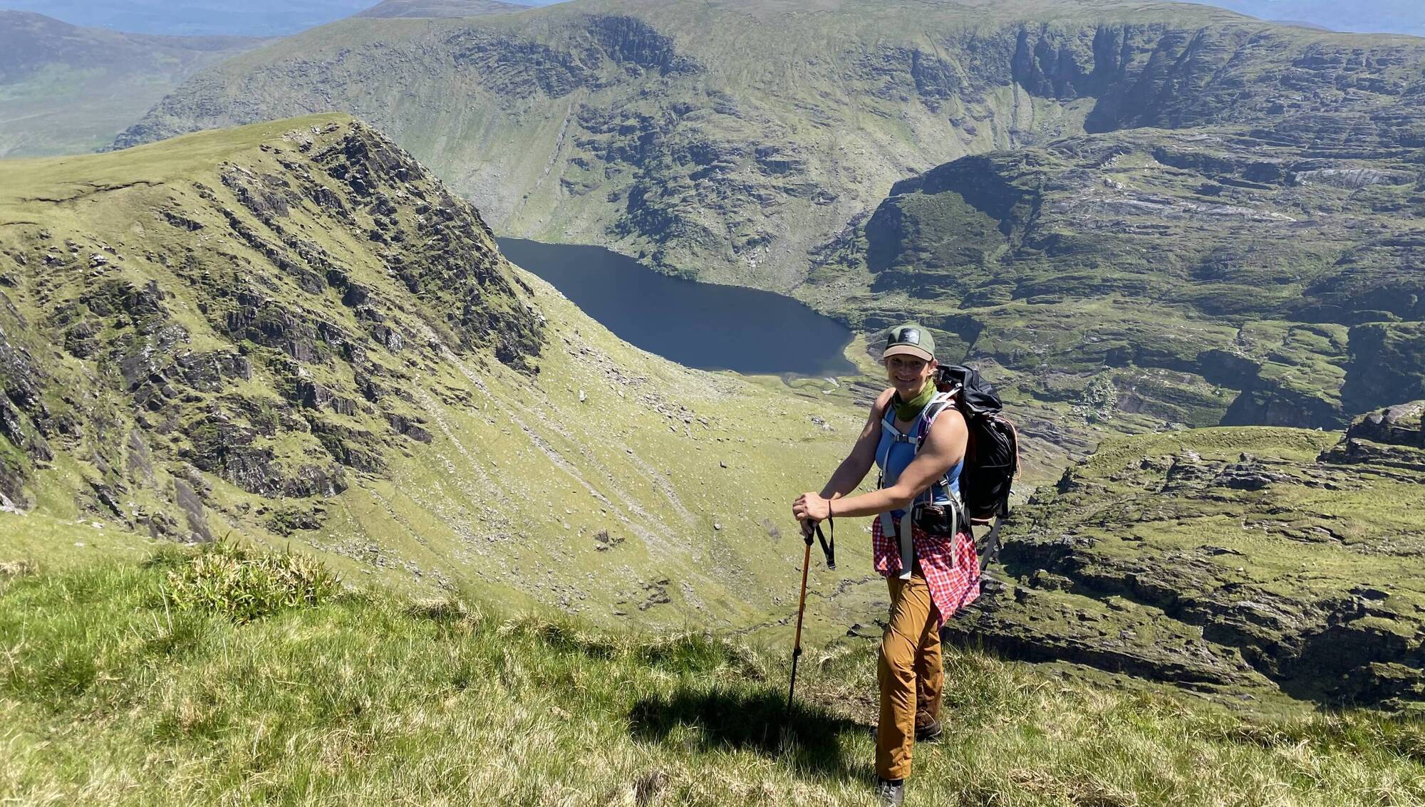 Barbara O’Donnell guides walkers along rugged paths towards a calm, blue lake nestled among steep hills.