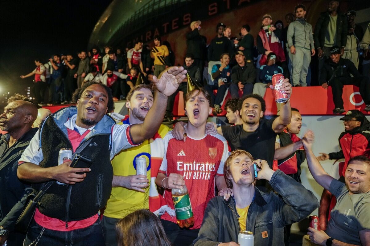 Arsenal fans celebrate at the Emirates Stadium after their club was crowned Premier League champions. Pic: Jeff Moore/PA Wire. Arsenal fans celebrate at the Emirates Stadium after their club was crowned Premier League champions. Pic: Jeff Moore/PA Wire.