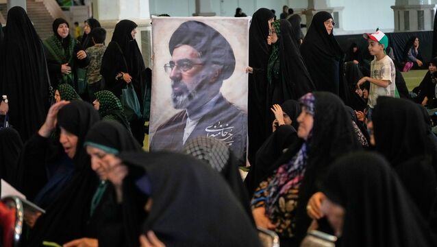 Women gather around a portrait of Iran’s Supreme Leader, Ayatollah Mojtaba Khamenei, during a ceremony honoring the armed forces and those killed in the war with Israel and the US at the Imam Khomeini Grand Mosque in Tehran, Iran (Vahid Salemi/AP)