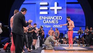 <p>Enhanced Games CEO Maximilian Martin kneels in front of Greek swimmer Kristian Gkolomeev during the medal ceremony following the Enhanced Games at Resorts World Las Vegas in Las Vegas, Nevada, on May 24, 2026. (Photo by ETIENNE LAURENT / AFP via Getty Images)</p>