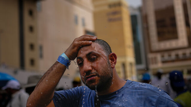 A Muslim pilgrim splashes water over his head to cool down outside the Grand Mosque (Altaf Qadri/AP)