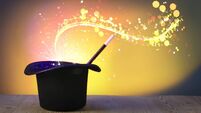 Wizard's hat with wand and magical light on color background
