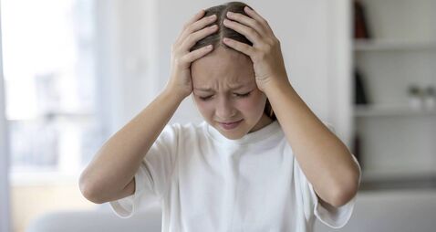 Stressed Young Girl Holding Her Head at Home