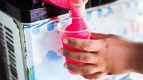 Human hand serving slushy drink from slushy  machine