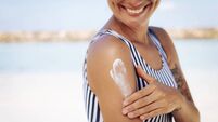 Smiling Woman Applying Sun Cream