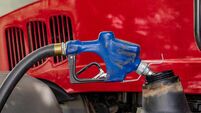 Diesel fuel nozzle fueling farm tractor. Farming input costs, fuel price increase and emissions pollution concept.