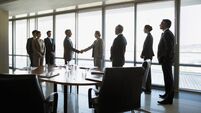 Business people shaking hands in conference room
