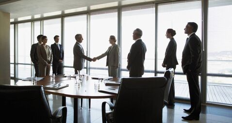 Business people shaking hands in conference room