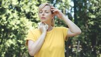Woman sweating while having a hot flash outside