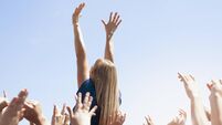 Woman with arms raised above crowd