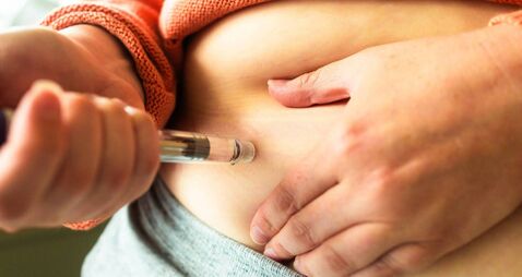 Woman using injection pen to administer weight loss drug