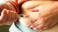 iStock-2217097273.jpg Woman using injection pen to administer weight loss drug