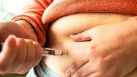 Woman using injection pen to administer weight loss drug