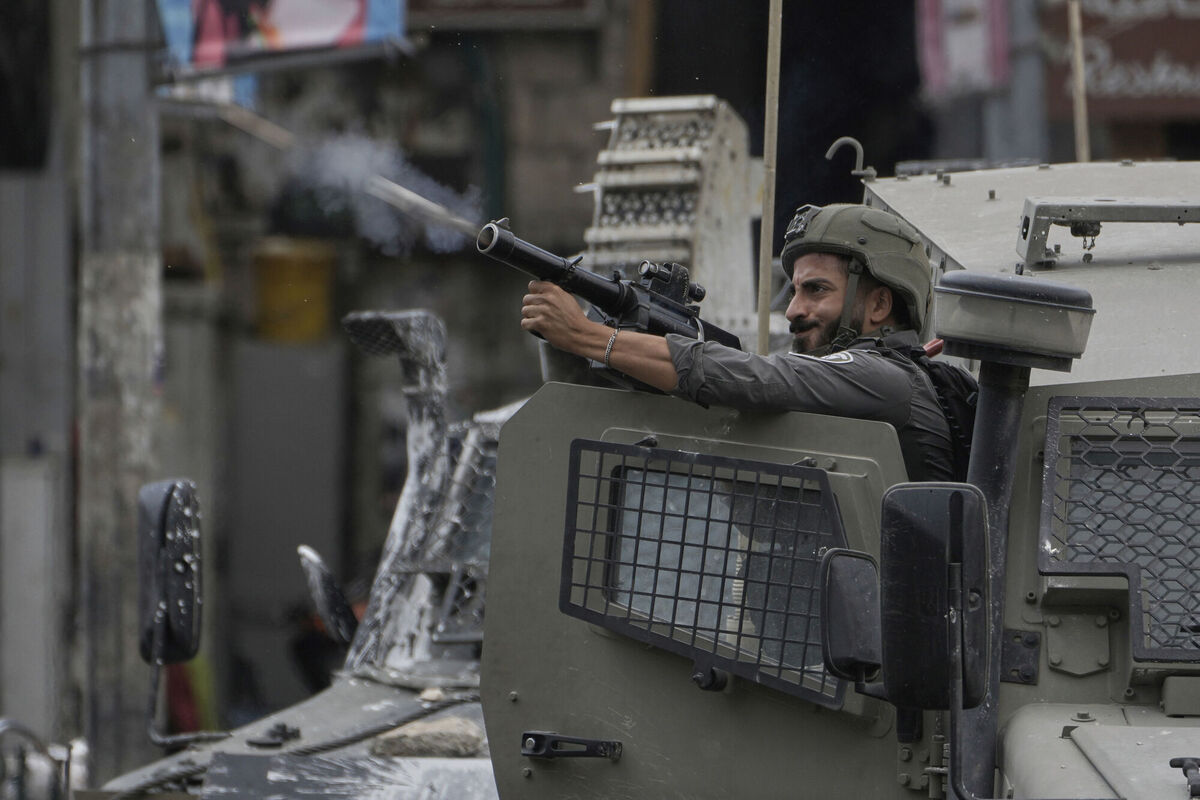 A member of Israeli security forces fires tear gas during a military raid in the West Bank city of Nablus. A member of Israeli security forces fires tear gas during a military raid in the West Bank city of Nablus.