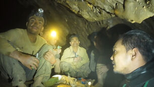Rescuers speaking to the villagers who were trapped and found in a flooded cave in Xaisomboun province, Laos (Benz Norrased Palasing Seascout Diving via AP)