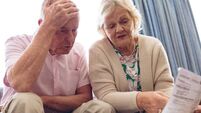 Senior couple discussing over medical bill while sitting on sofa at retirement home