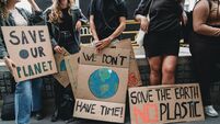 People are holding banner signs while they are going to a demonstration against climate change