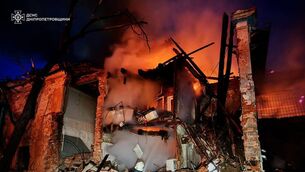 A rescue worker puts out a fire at a residential building (Ukrainian Emergency Service via AP)