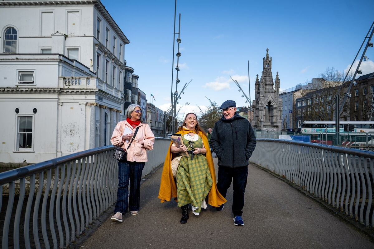 Only minutes into the tour and Angela Newman of Hysterical Histories Cork already has Irish Examiner Features writer Deirdre McArdle and her father Austin Murphy in flying form as they cross Nano Nagle Bridge. Picture: Chani Anderson