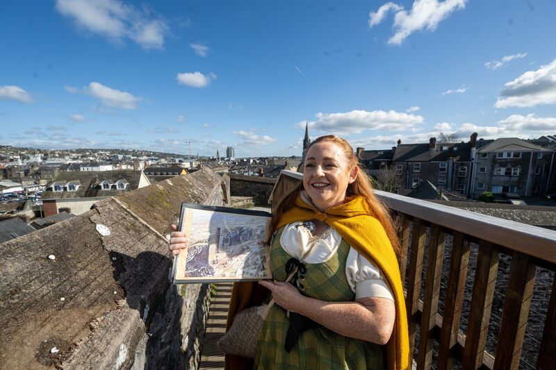 Standing on the balcony at Elizabeth Fort, Angela Newman of Hysterical Histories Cork holds up an old image of medieval Cork while the modern city stretches to the horizon behind her as she guides Irish Examiner Features writer Deirdre McArdle and her father Austin Murphy. Picture: Chani Anderson