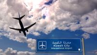Airplane silhouette landing in Kuwait City. Arrival with international airport direction signboard and blue sky in background. T
