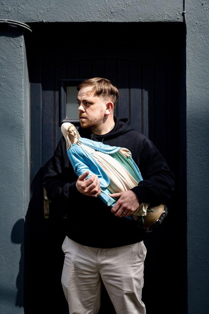 Craig holds the statue of the Virgin Mary outside his late grandmother Kathleen O’Sullivan’s former home on Cathedral Avenue, where she maintained a Eucharistic altar for many years. 