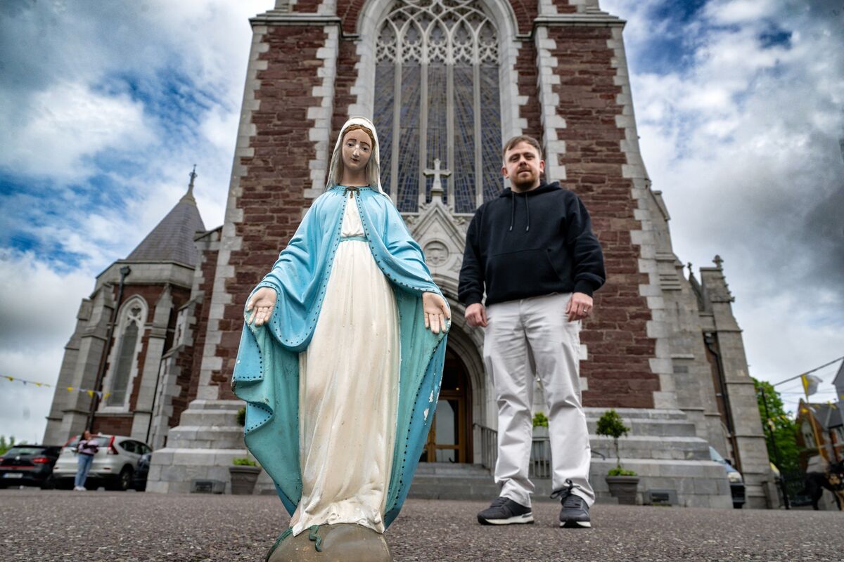 Craig stands beside a statue of the Virgin Mary outside the Cathedral of St Mary and St Anne.