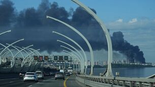 A plume of black smoke is seen over the port of St Petersburg (AP)