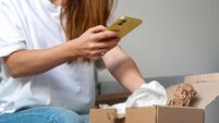 Express delivery. Receiving online purchase. Woman unpacking cardboard and taking pictures of purchases.