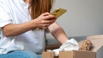 Express delivery. Receiving online purchase. Woman unpacking cardboard and taking pictures of purchases.