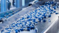 Blue Capsules on Conveyor at Modern Pharmaceutical Factory. Tablet and Capsule Manufacturing Process. Close-up Shot of Medical D