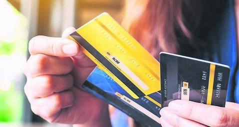 a woman holding and choosing credit card to use