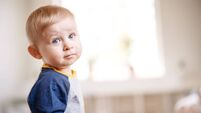 Cute boy standing in the white room