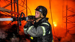 A rescue worker puts out a fire at a storage facility after a Russian strike in Kharkiv, Ukraine (Ukrainian Emergency Service via AP)